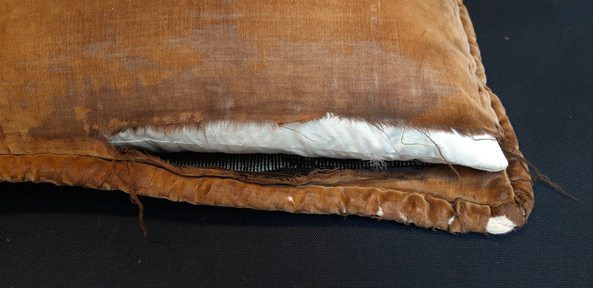 Putetrekk med fjærpute. Brodert i ullgarn. Bakside av brun fløyel og kantet med samme fløyelsstoff.