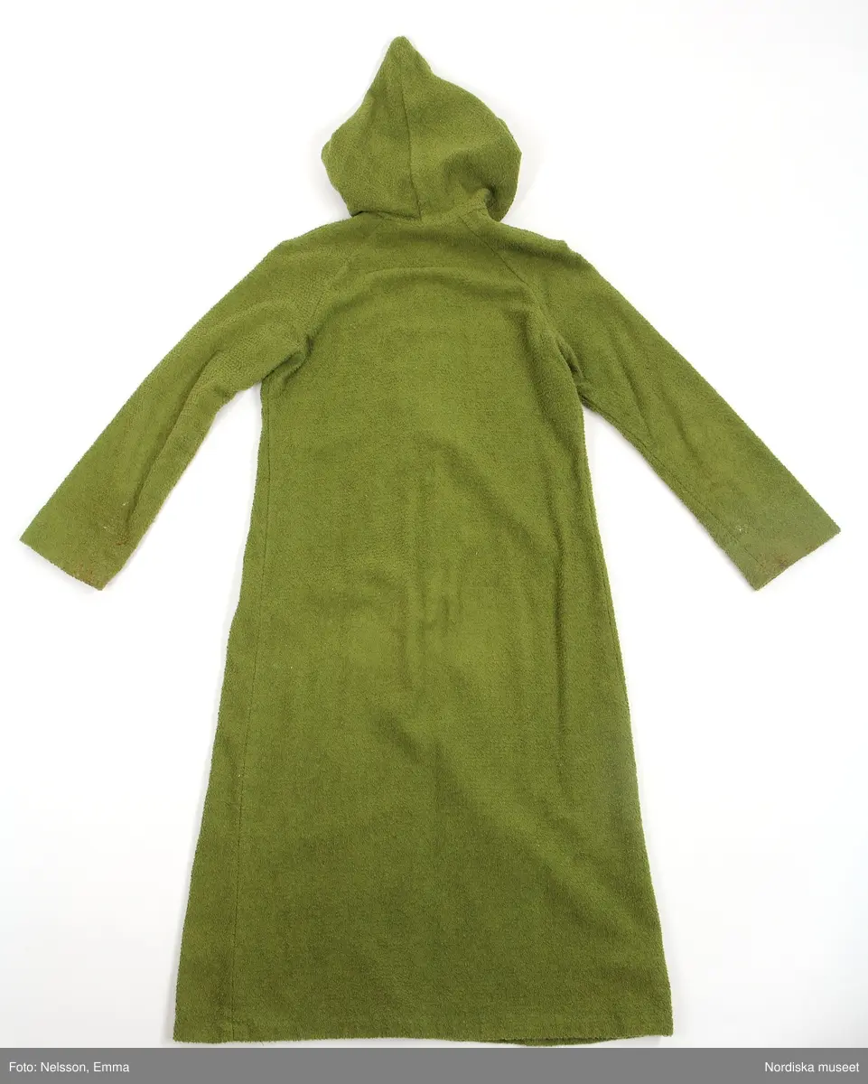 Katalogkort:
"Morgonrock av grön frotté. Utställd modell med huva och långa ärmar. Dragkedja från halslinning till 36 cm från fåll."