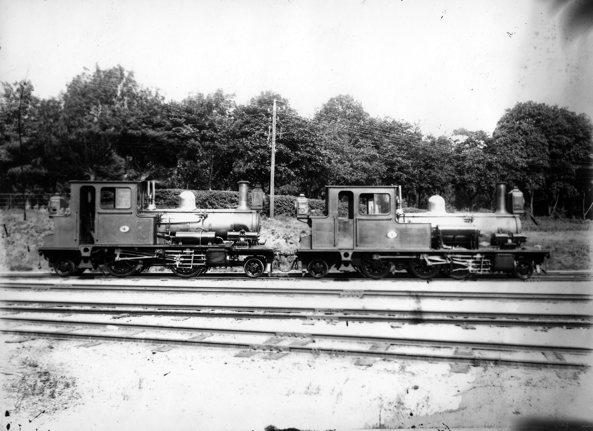 Lokomotiv nr. 1 og nr. 4 på Kristiansand stasjon.
Ca 1900.
Duplikat SBN10045.

Type XXI nr. 1	Til høyre
Type XXII nr. 4	Til venstre