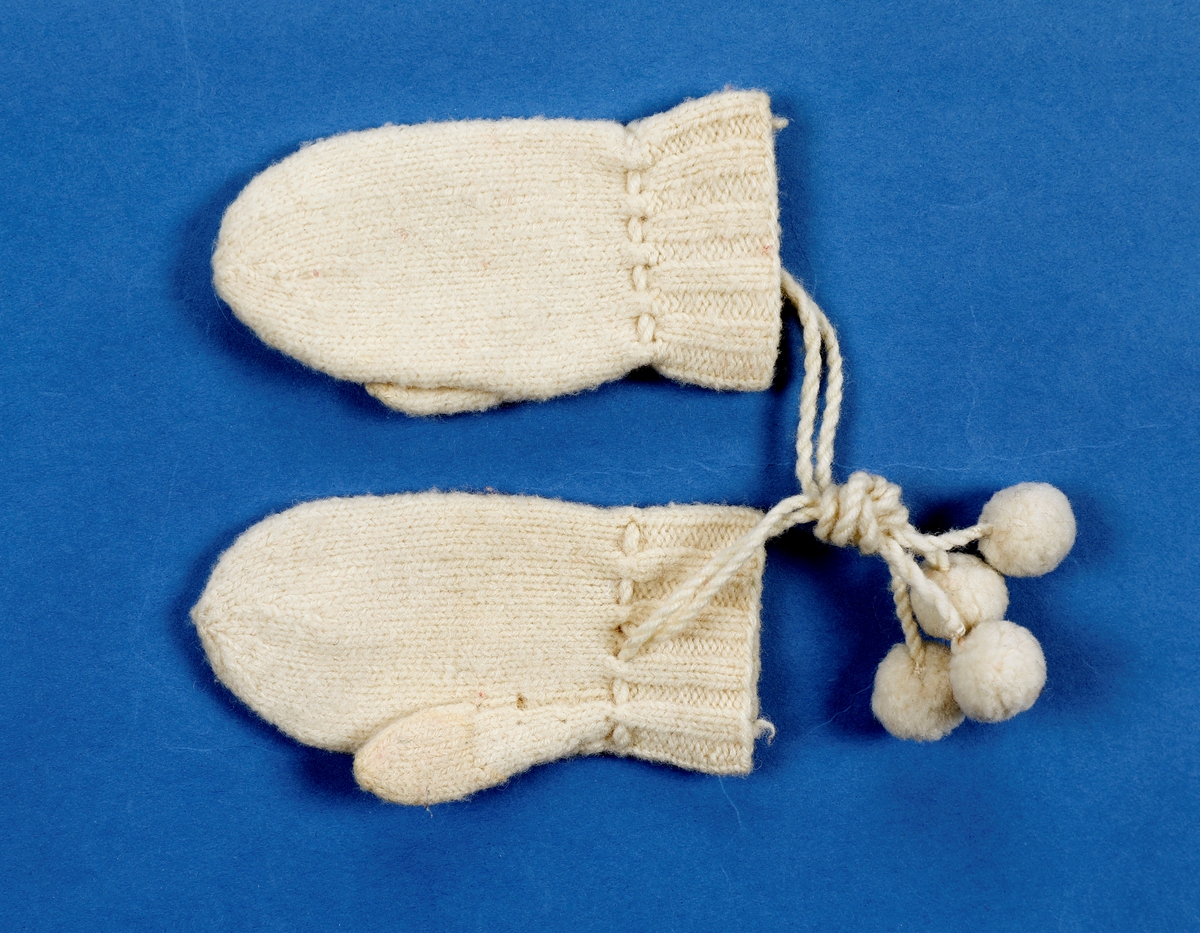 Dåpskjole med tilbehør: belte, lue, votter.  

Dåpskjole med isydde ermer, skulderstykke, langt vidt skjørt med rynker. Dekorteknikk: Foldelagte kapper 2 foran, 1 bak festet med blonde. Sydde legg, 5 stk., festet med blonde. Åpning bak 40 cm med 2 knytteband. pyntet med rosa bånd.
Lue:bobinet foret med rosa sateng. 
belte: bredt og langt med pynt av blonder og biser i hver ende.
Strikkede votter, tradisjonell form med knyttesnor.