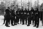 Ett tiotal militära flygare står i full utrustning på ett flygfält, vintertid,  cirka 1941-1944.

Bildtext vid foto: 