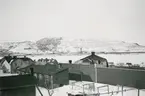 Exteriör av byggnader och fjäll vid Kirunavaara, vintertid, cirka 1942. Med gruvbyggnader i bakgrunden.

Bildtext vid foto: 