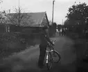 En flygsoldat står med cykel på en gata i Eslöv, 1943.

Bildtext vid foto: 