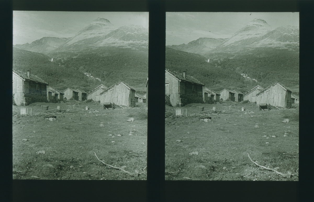 Setergrend med flere tømmerbygninger, beliggende ved Stordal, Møre og Romsdal. Tilhører Arkitekt Hans Grendahls samling av stereobilder.