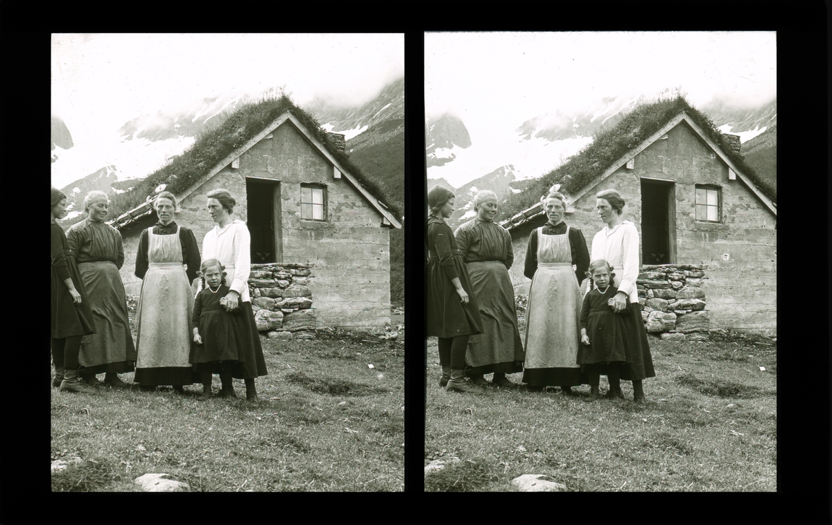 Kvinner og barn foran mursteinsbygning på stølen. Tilhører Arkitekt Hans Grendahls samling av stereobilder.