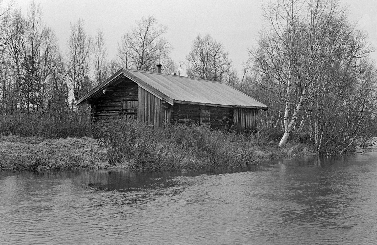 Bu ved elva Tufsinga, som renner gjennom Tufsingdalen i Os kommune i Nord-Østerdalen. Bua var en laftekonstruksjon som var plassert med langsida mot vassdraget. Den hadde bølgeblikktekket saltak. Inngangsdøra var plassert på sørgavlen og på østre langvegg, mot vassdraget, ser vi et vindu som var stengt med lem. Bygningen hadde en forlengelse i bordkledd bindingsverk i nordenden. Også under det utkragete taket i sørenden, ved sida av inngangsdøra, var det en bordkledd bindingsverkskonstruksjon, antakelig et matskap.   Bildet er tatt i forbindelse med dokumentasjon av gjeddefiske med tufsingdølene Jo Bakken og Joseph Bakken som hovedaktører.