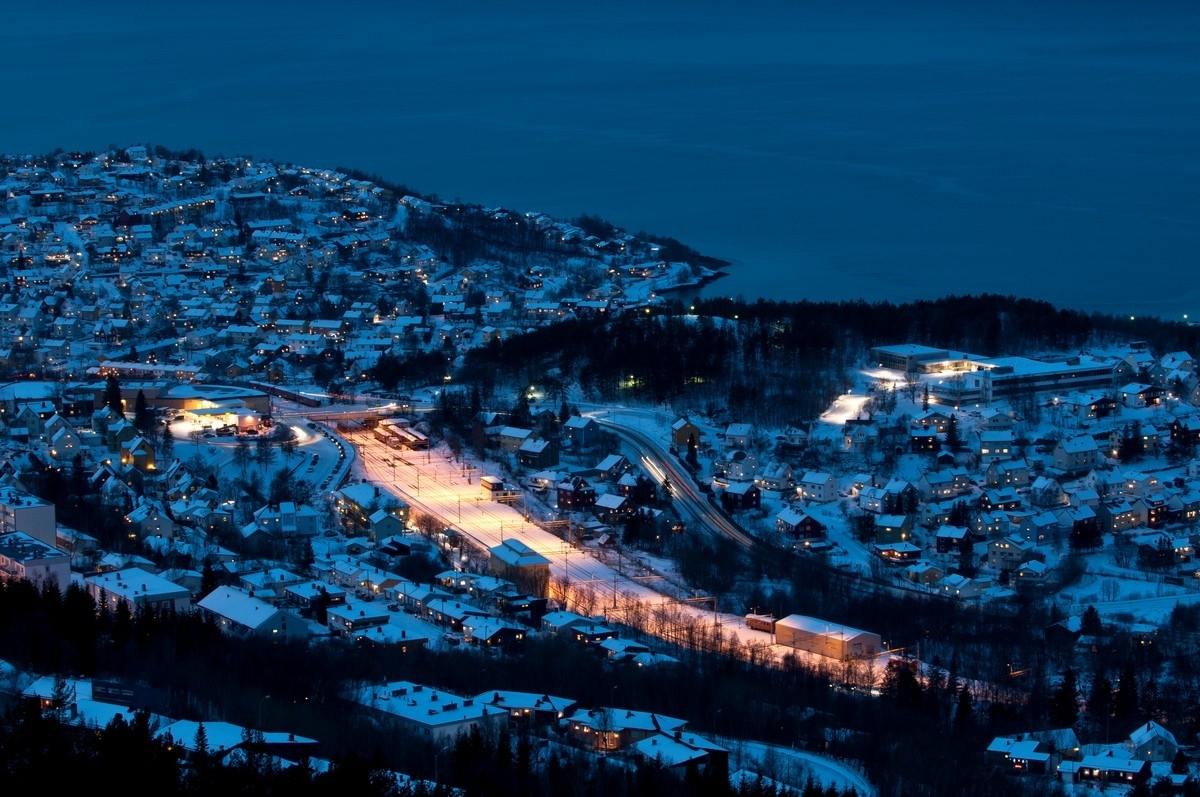 Narvik jernbanestasjon opplyst i midten. Bebyggelse på Frydenlund og Taraldsvik. Mørketid. 30 des 2011.