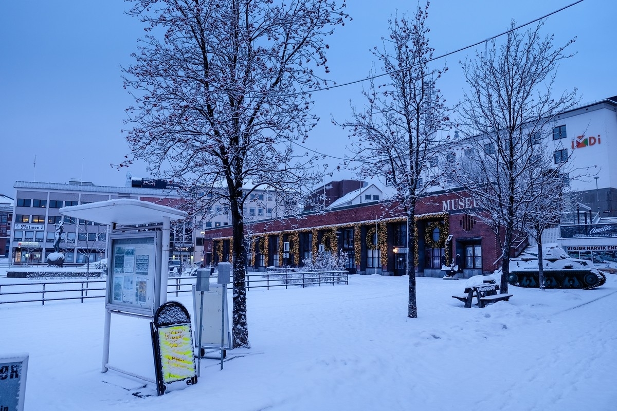 Narvik torv med Krigsminnemuseet i torvhallen og med tanks i utstilling til høyre.. Søndagsstille by i mørketid. Foto: 3. januar 2015.