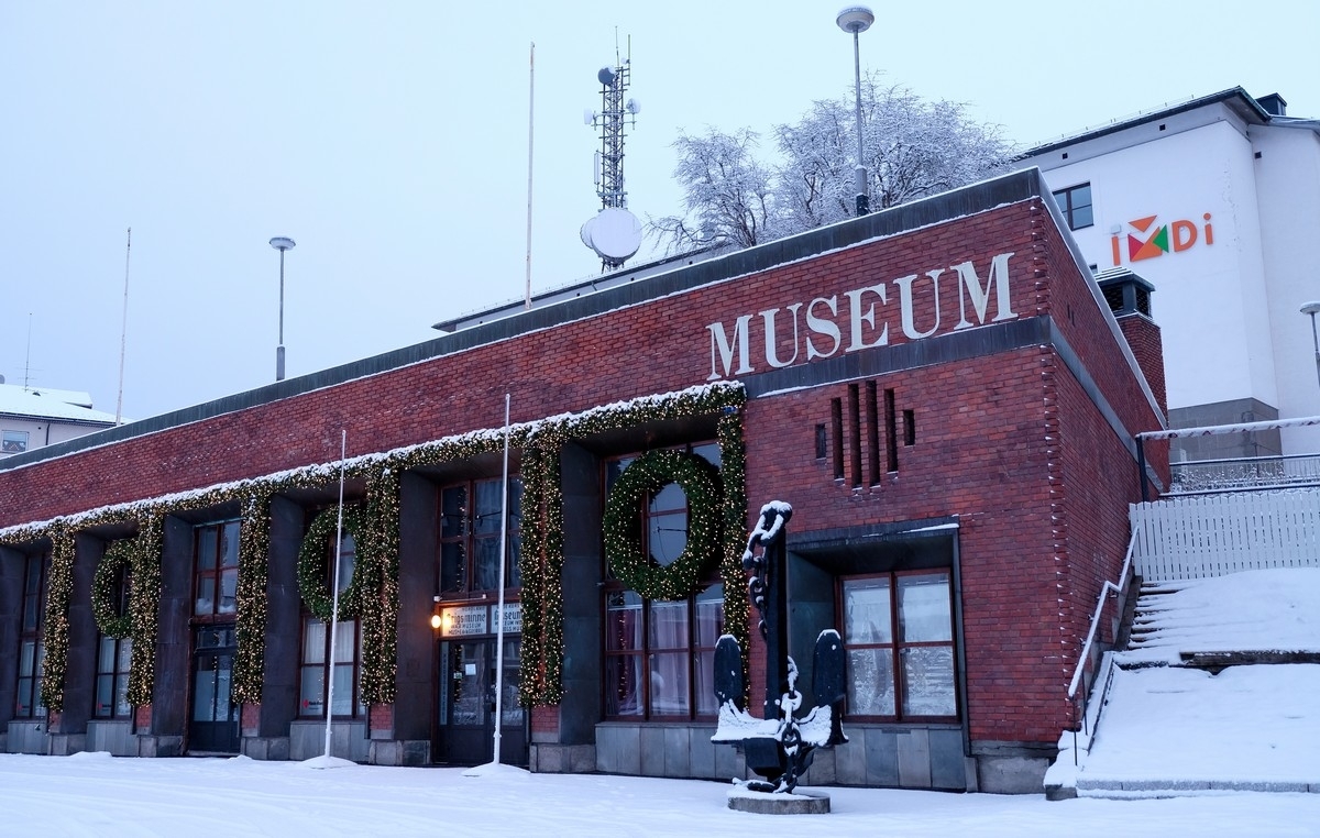 Krigsminnemuseet i Torvhallen søndre del. Hvitt hus bak tidligere post og telegraf i Dronningens gate. Søndagsstille by i mørketid. Foto: 4. januar 2015.