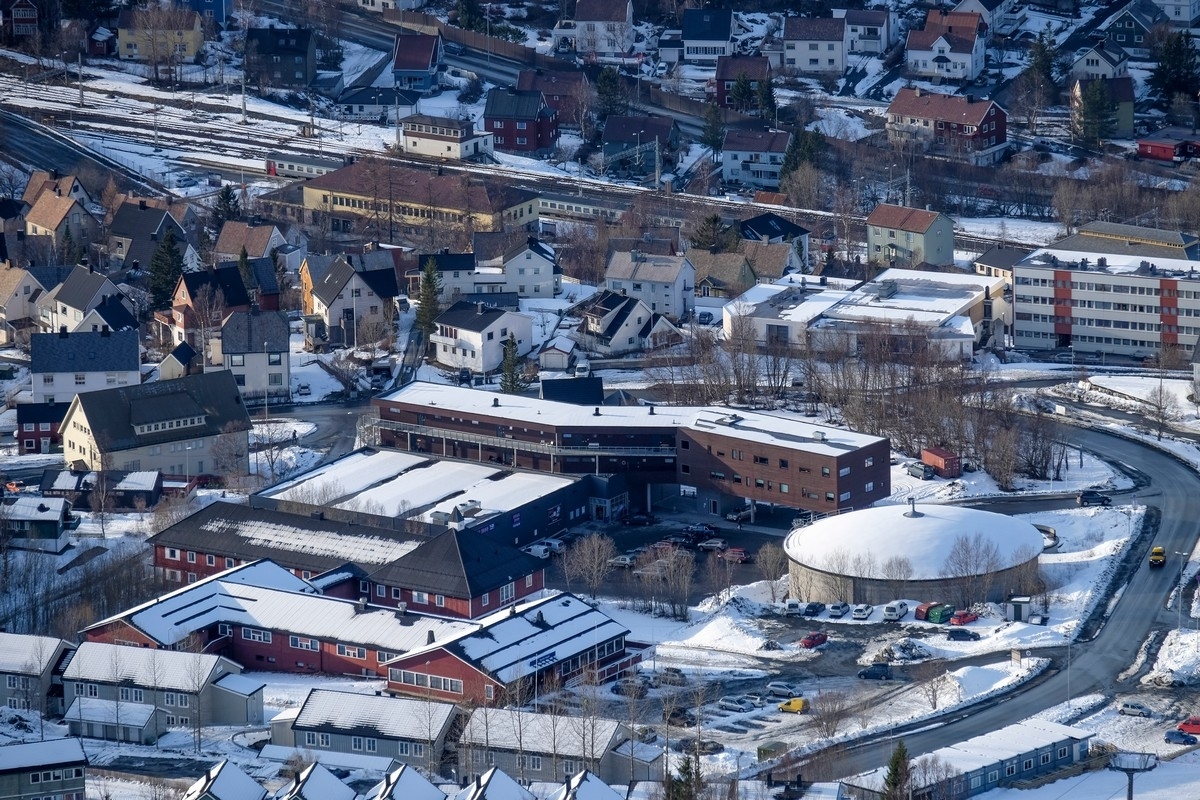 Det tidligere vannbasseng-området, nå Rema 1000 og kontor/boliger. Til  høyre reduksjonsbasseng (rund bygning) for vann. Nærmest Narvik sportell. I bakgrunnen jernbanestasjonen (gul bygning) med personvogner.11. april 2015