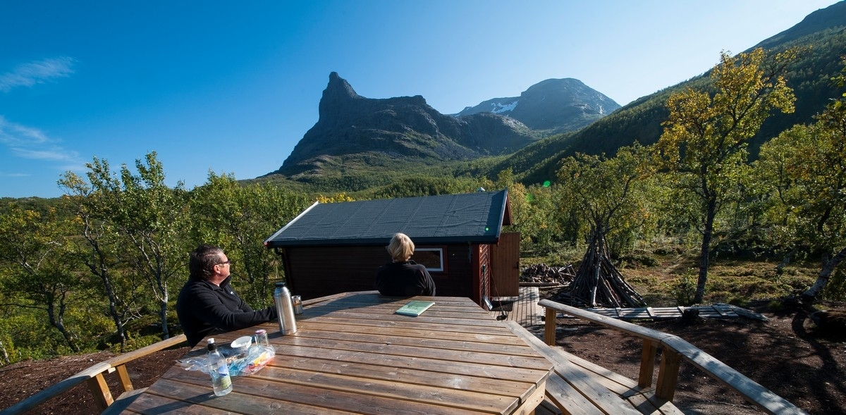 To personer rundt bord, nær Funnhytta. Tøttatoppen bak. Bildereportasje fra Tøttadalen, Førstevann, Pumpvann og FUNN-hytta. Artikkel i Fremover lørdag 19. sept 2015.Foto 10. sept 2015