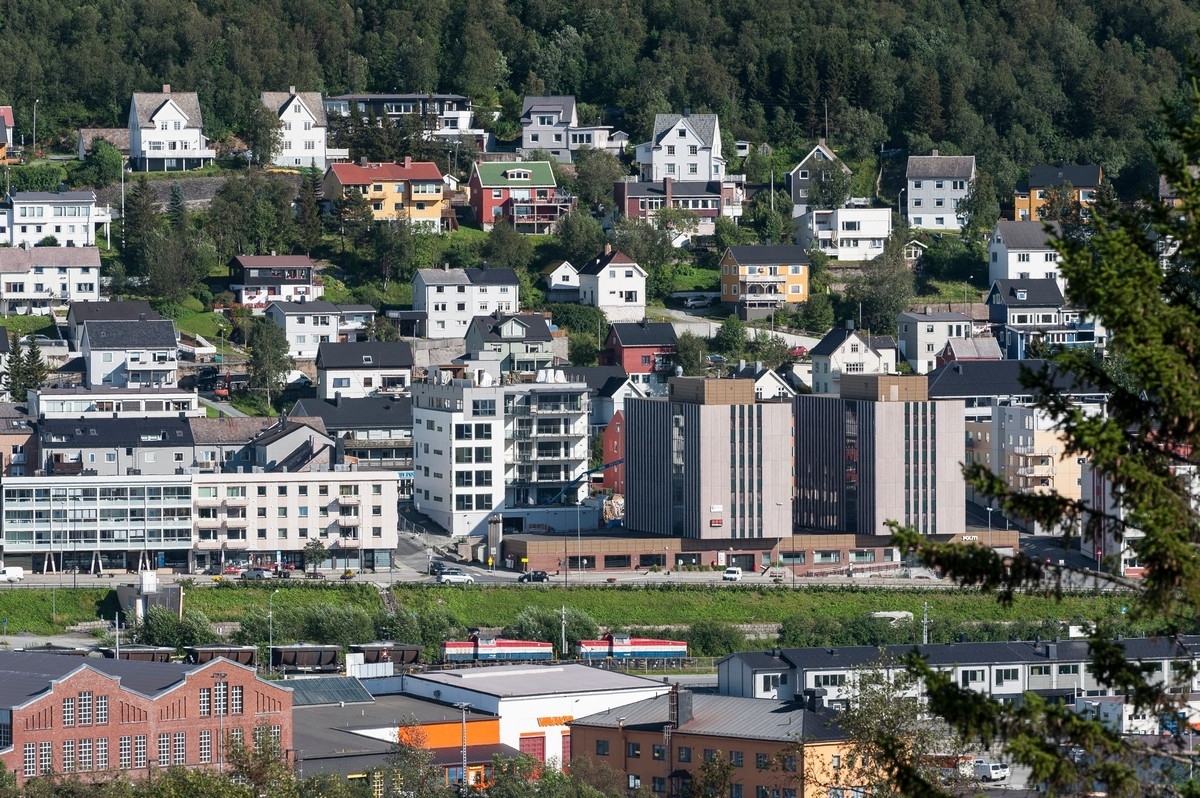 Narvik. Nedre del av sentrum, gamle post og politihus, bak her nytt boligblokk. Bilde fra en serie bilder tatt ettermiddag fra området ved Solhaugen, dvs tvers over byen. Deler av serien viser det nye boligfeltet under utbygging i Øvre Fjellheim.