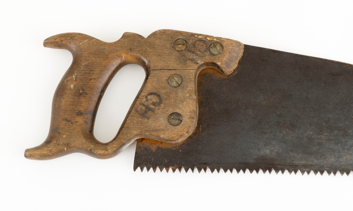 Sag, såkalt bladsag, brukt i snekkerarbeid. Saga er 64,5 centimeter lang, målt fra et punkt midt imellom handtakets ytterender og bladets ytterende. Bladet er snaut 55 centimeter lagt. Det er cirka 13,5 centimeter bredt i den bakre enden og 3,4 centimeter bredt i den fremre enden. Tannlinja er 54,5 centimeter lang og rettlinjet. Saga har 98 tenner som er cirka 0,4 centimeter lange. Den bakre halvdelen av bladryggen har en liten konveks krumning. Stålet i bladet (klingen) er om lag 0,1 centimeter tjukt. Saga har et trehandtak med et spor som den bakre enden av bladet er felt inn i og festet ved hjelp av fire gjennombrutte messingskruer. I den bakenforliggende delen av handtaket er det et ovalt hull til å gripe i og aller bakerst er det to bakovervendte «horn», hvorav det ene gav støtte til kløfta mellom tommelfinger og pekefinger. Handtaket har også ei lita, sirkelrund messingplate med innskriftetn «WARRANTED  SUPERIOR». Handtaket er også stemplet «CM», som antakelig er initialene til en tidligere eier,