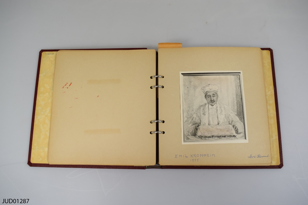 Rött album med monterade reprofotografier av Olga Raphaels konst.