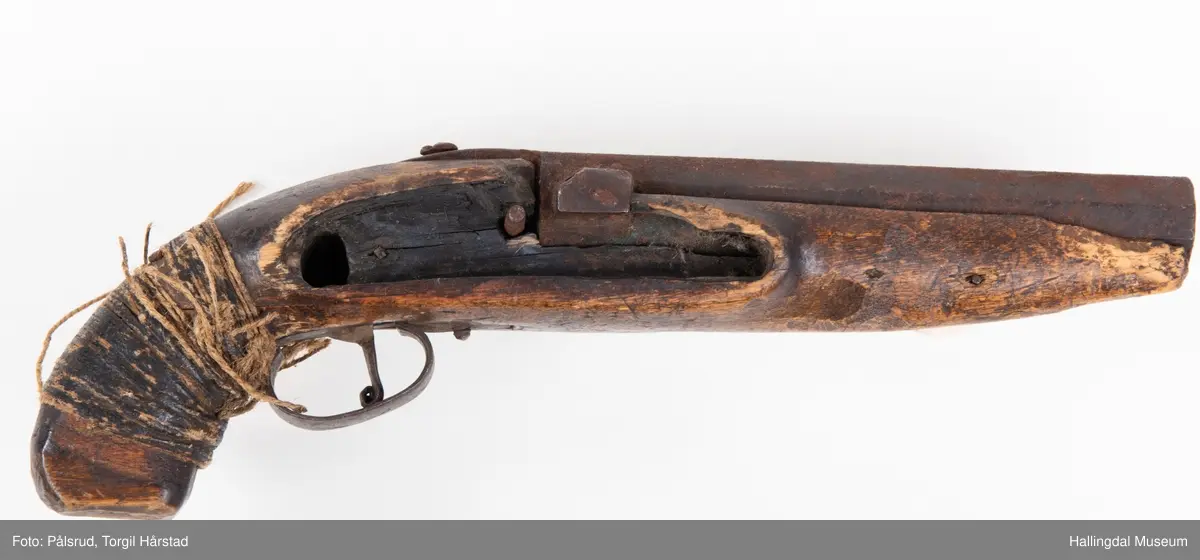 Perkusjonspistol med hyssing surret rundt skjeftet. Mangler låsen og ladestokk. Avkortet eller tilpasset skjefte.