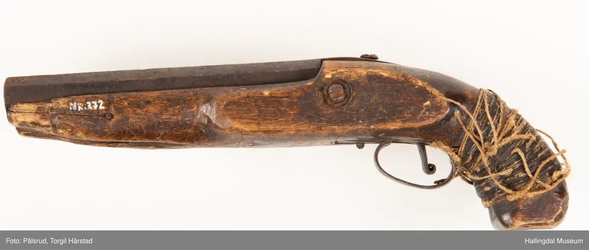 Perkusjonspistol med hyssing surret rundt skjeftet. Mangler låsen og ladestokk. Avkortet eller tilpasset skjefte.