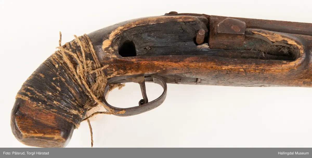 Perkusjonspistol med hyssing surret rundt skjeftet. Mangler låsen og ladestokk. Avkortet eller tilpasset skjefte.