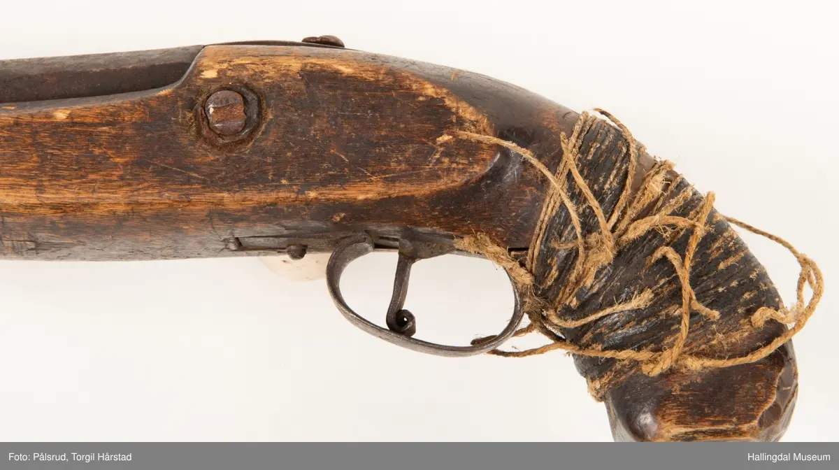 Perkusjonspistol med hyssing surret rundt skjeftet. Mangler låsen og ladestokk. Avkortet eller tilpasset skjefte.