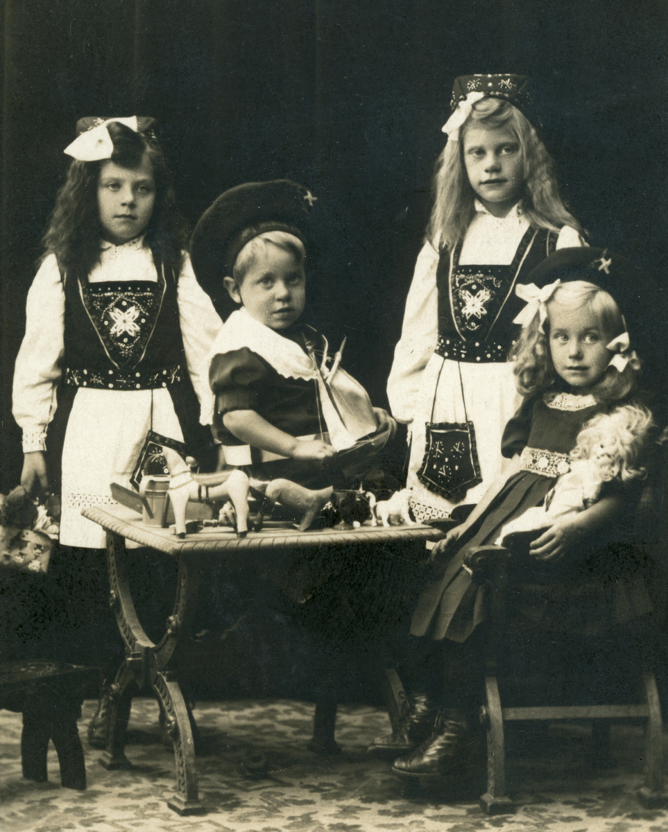 Tre jenter og ein gut kledd i finklede. Kitty, Gudrun, Hanna og Hans