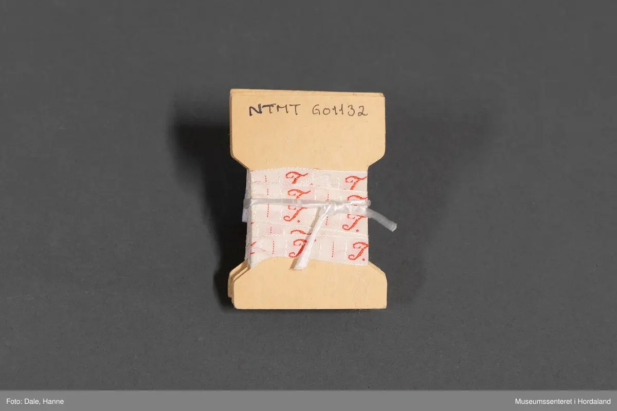 Vevd bokstavbånd med bokstaven "T".