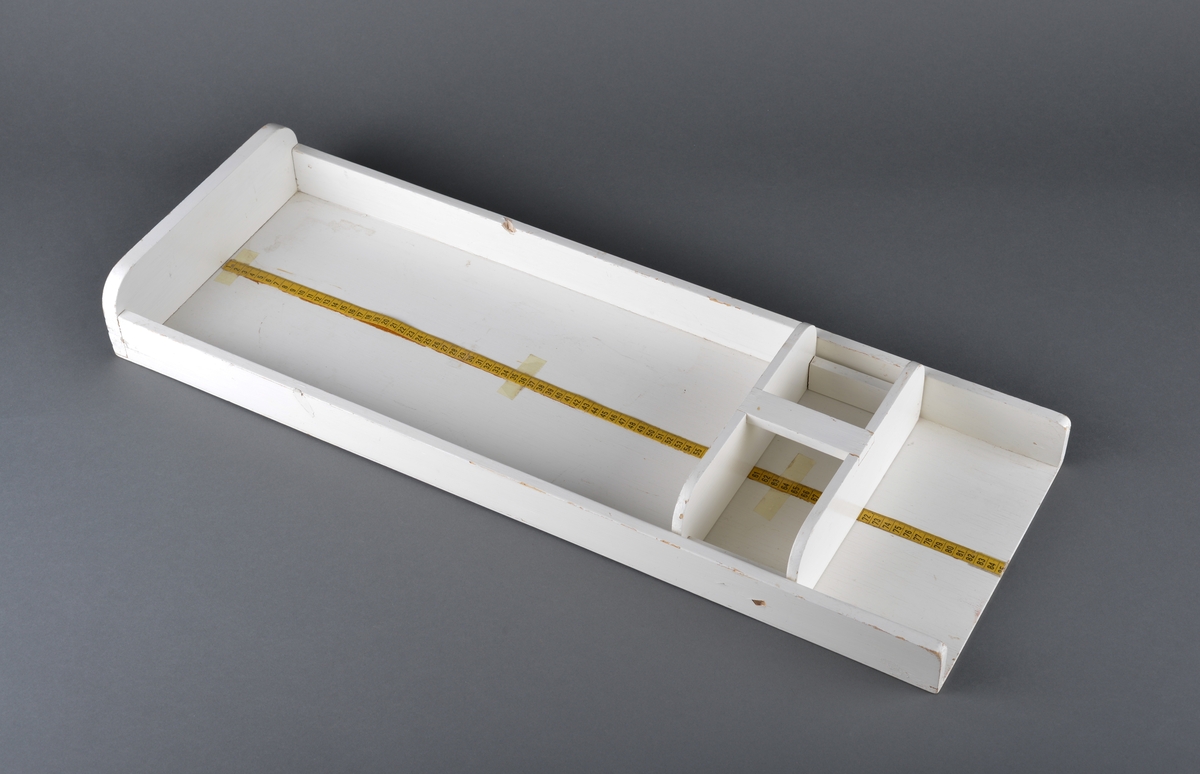 Brett beregnet til måling av spebarn.
Består av to deler. En trekasse og et løst skyvbart håndtak for å regulere etter barnets lengde.