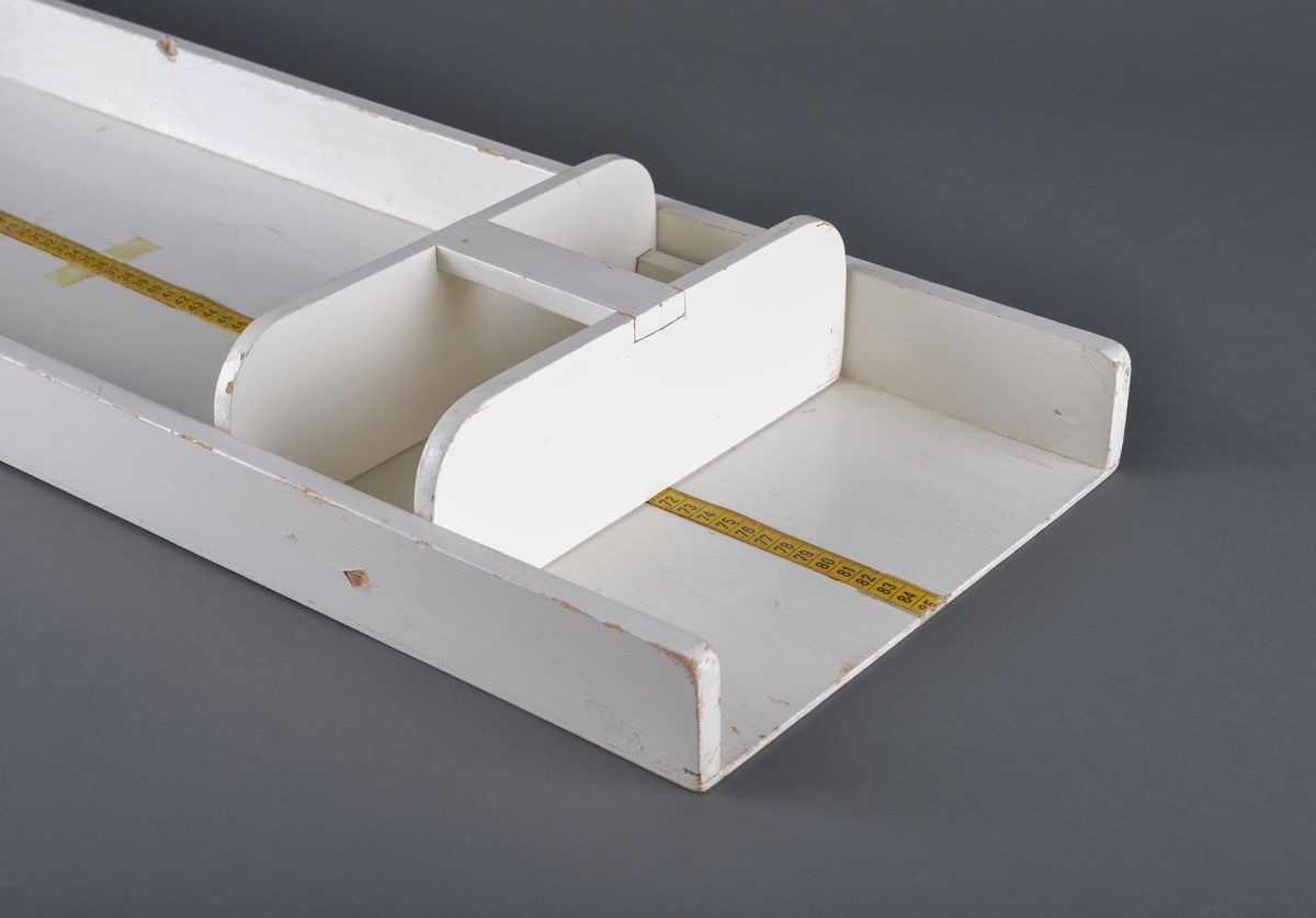 Brett beregnet til måling av spebarn.
Består av to deler. En trekasse og et løst skyvbart håndtak for å regulere etter barnets lengde.