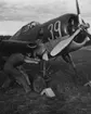 Två flygsoldater drar igång motorn på flygplan J 22 märkt nr 39 på ett flygfält, cirka 1943.

Foto skannat ur album: 'Minnen från Min kommistid 1940-1944'