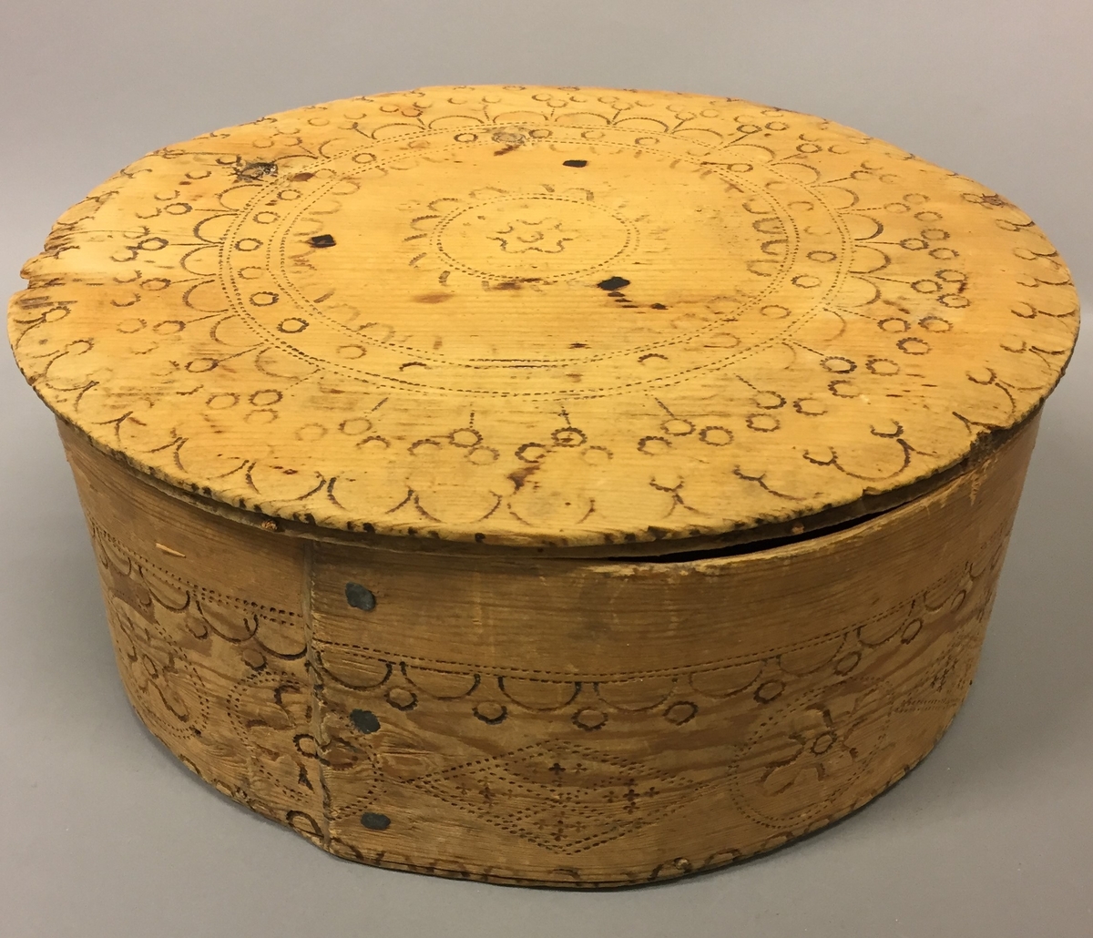 Kledeask med lok. Brennmerkt. Noko oval form. Sveipa. "Aase Johans datter 1719" under loket. XXIV under asken. AJ og AAJ skrive inne i asken, fleire stader.Rikt dekorert både på lok og kring kanten av asken. Krossar, mjuruspjell, sirklar og halvsirklar. Restar etter trepluggar. Sveipen er festa saman med tre metallspiker.