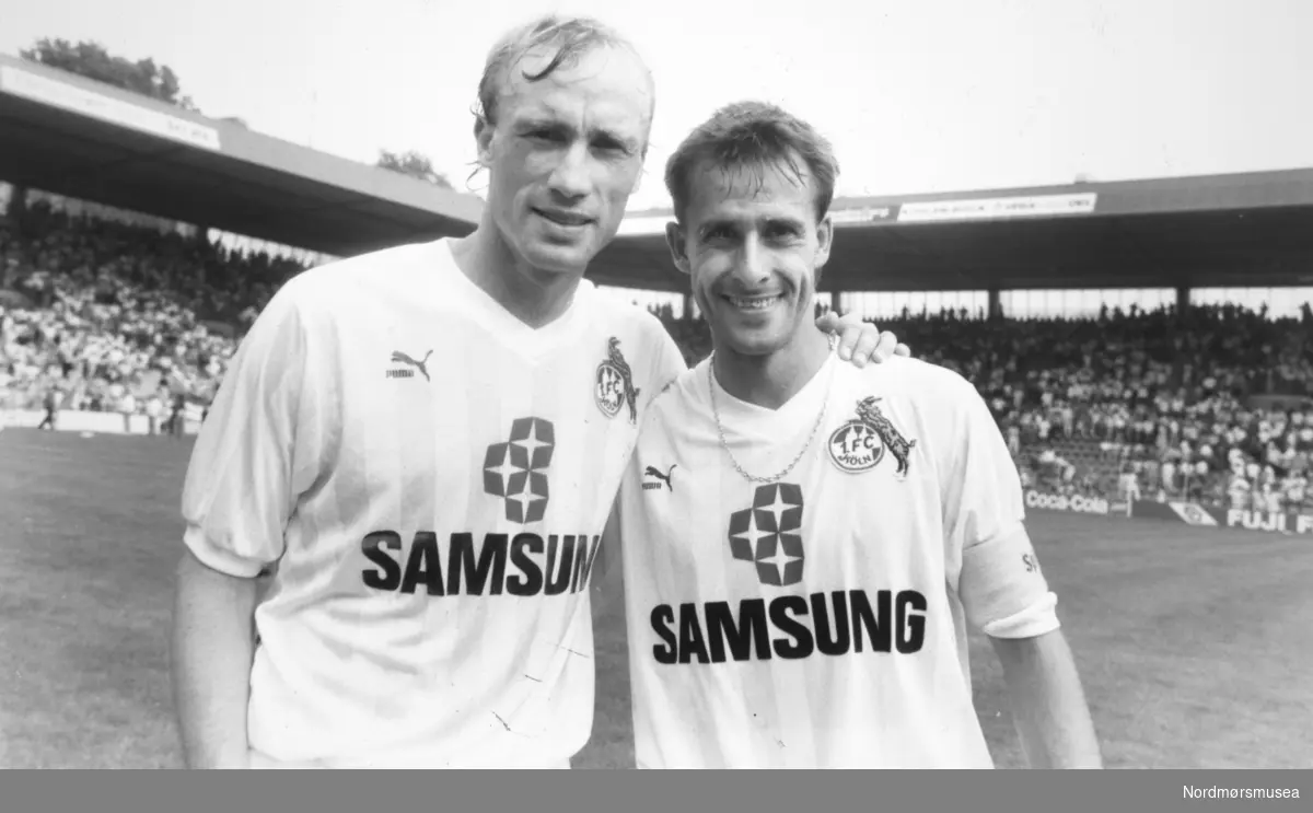 Anders Giske og Pierre Littbarski. spiller i 1. F C Kølen. På stadioen 1989.
Bildet er fra avisa Tidens Krav sitt arkiv i tidsrommet 1970-1994. Nå i Nordmøre museums fotosamling.