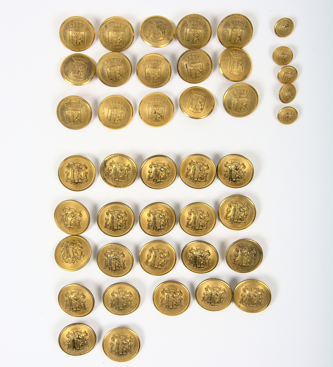 Uniformsknappar av mässing. Varbergs kommunvapen. Totalt 42 stycken av 3 olika sorter.

15 st. Varbergs kommunvapen krönt av en krona. Diam: 23mm.
5 st. Varbergs kommunvapen krönt av en krona. Diam: 13mm.
22 st. Varbergs kommunvapen inringad av en sköld. Diam: 23mm.