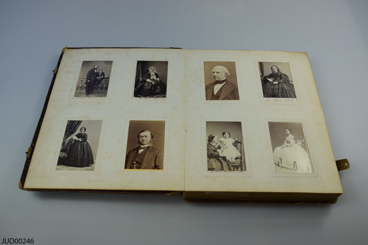 Fotoalbum i skinn med guld- och metalldekor. Porträtt i visitkortsformat.