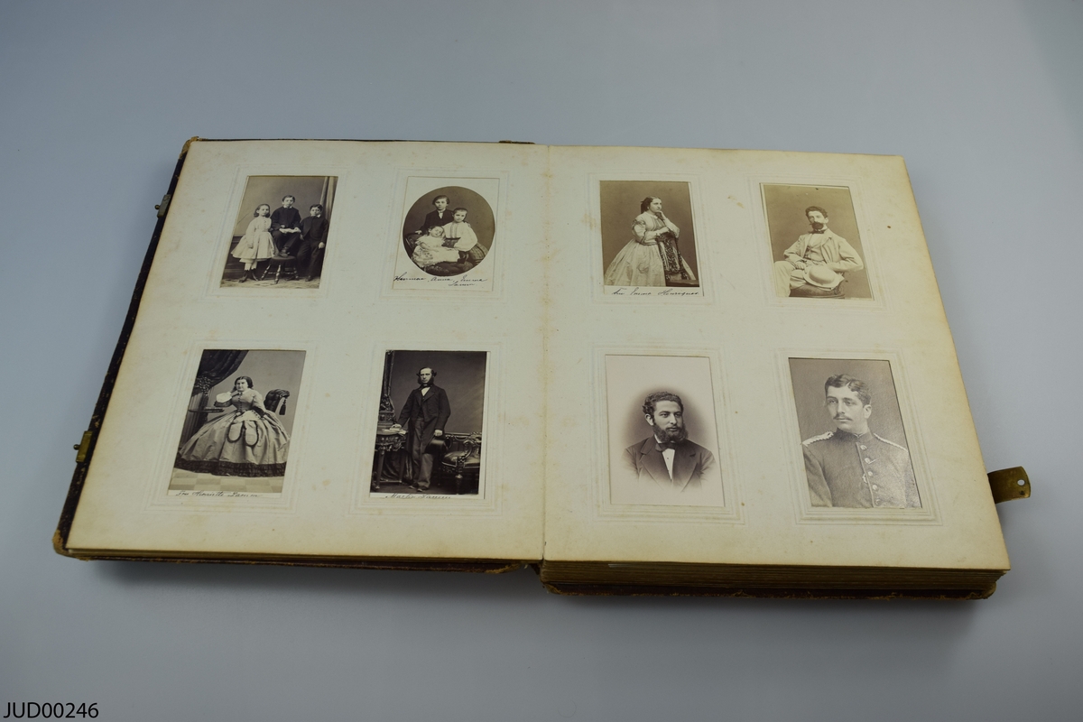 Fotoalbum i skinn med guld- och metalldekor. Porträtt i visitkortsformat.