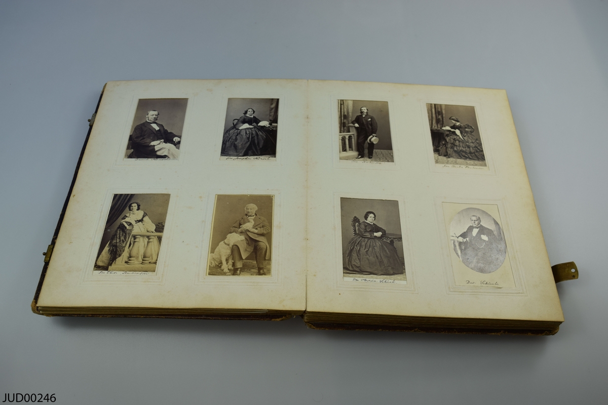 Fotoalbum i skinn med guld- och metalldekor. Porträtt i visitkortsformat.