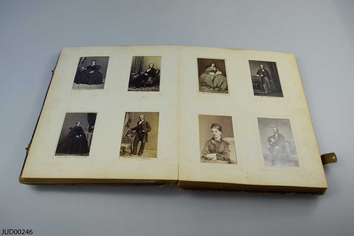 Fotoalbum i skinn med guld- och metalldekor. Porträtt i visitkortsformat.