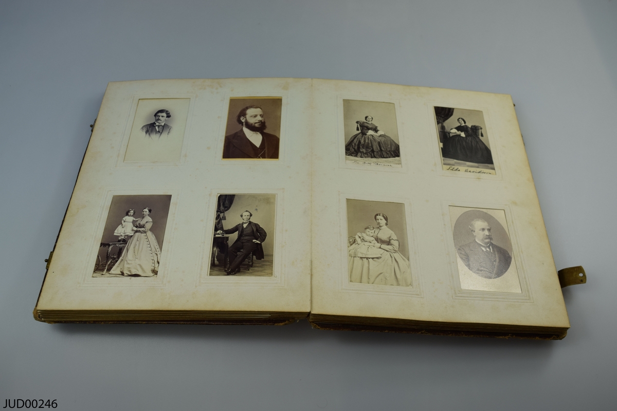 Fotoalbum i skinn med guld- och metalldekor. Porträtt i visitkortsformat.