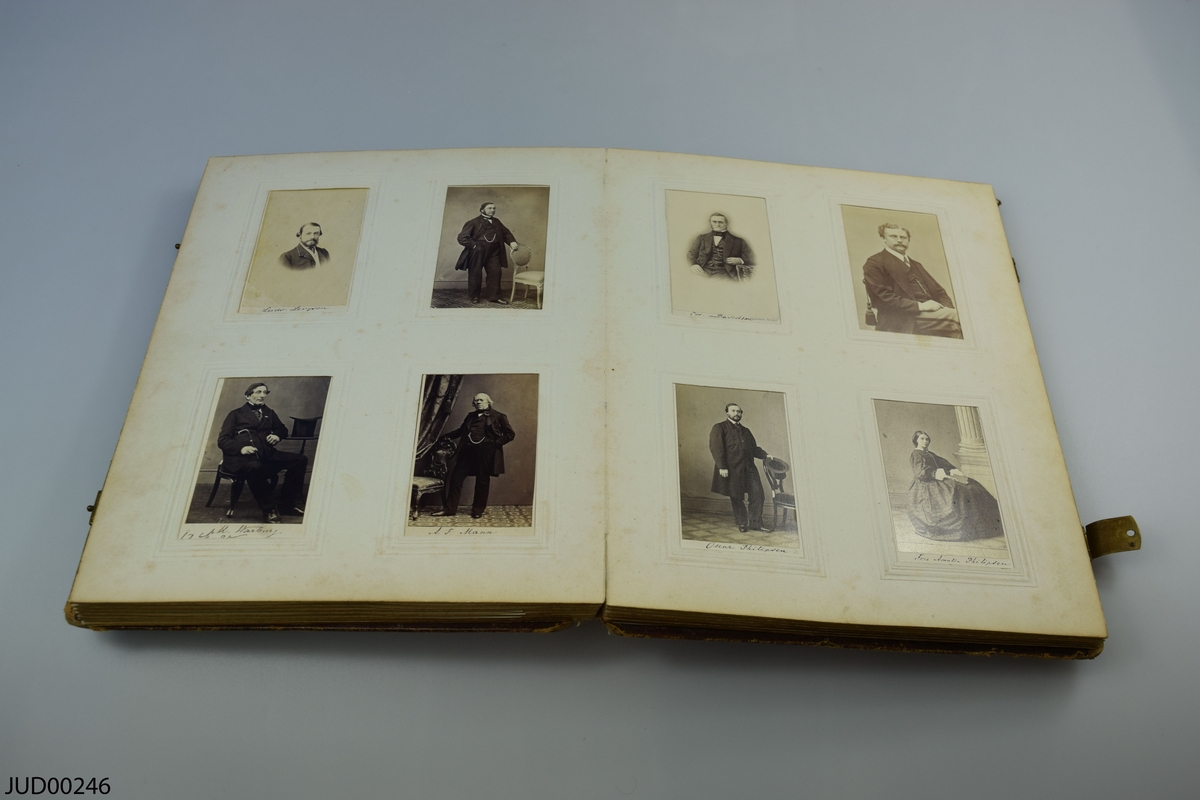Fotoalbum i skinn med guld- och metalldekor. Porträtt i visitkortsformat.