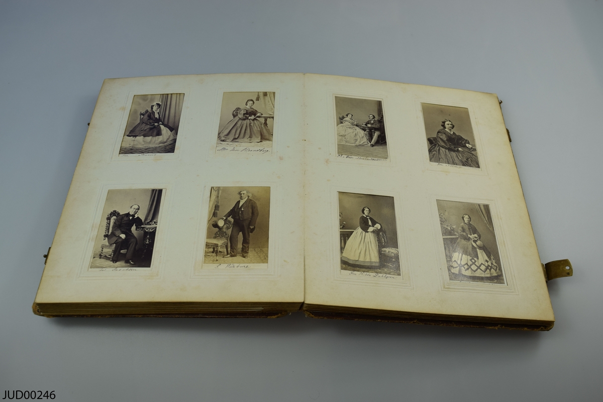 Fotoalbum i skinn med guld- och metalldekor. Porträtt i visitkortsformat.