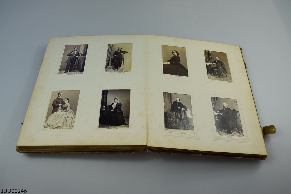 Fotoalbum i skinn med guld- och metalldekor. Porträtt i visitkortsformat.