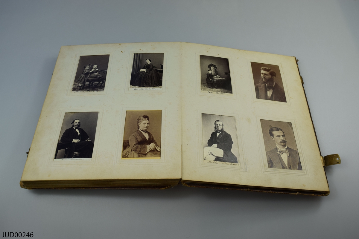 Fotoalbum i skinn med guld- och metalldekor. Porträtt i visitkortsformat.