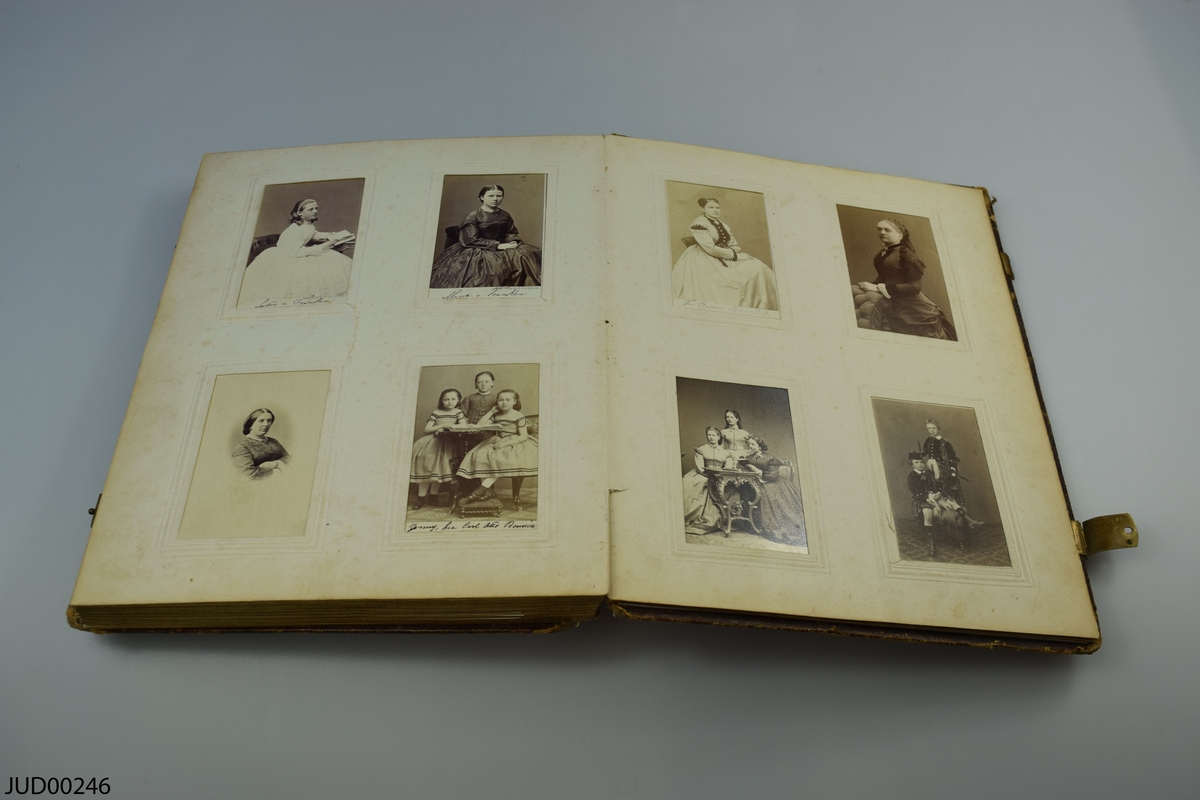 Fotoalbum i skinn med guld- och metalldekor. Porträtt i visitkortsformat.