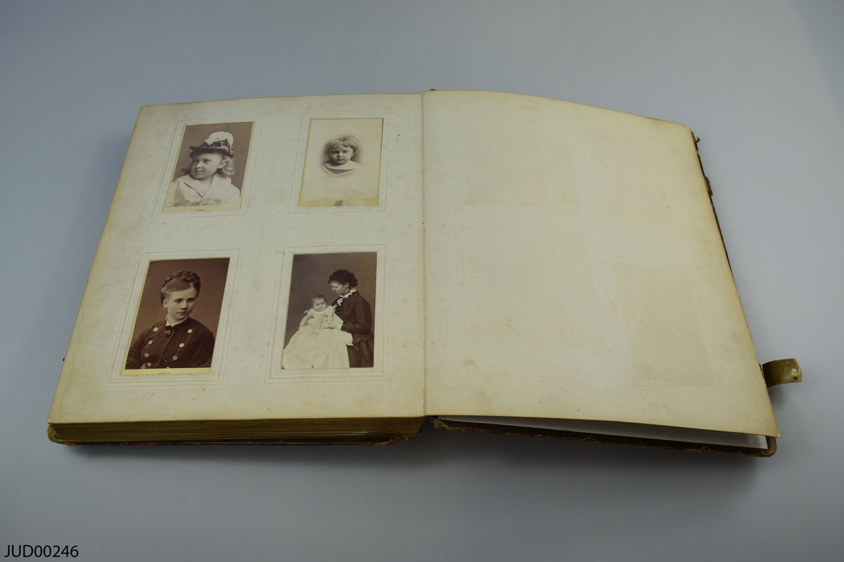Fotoalbum i skinn med guld- och metalldekor. Porträtt i visitkortsformat.