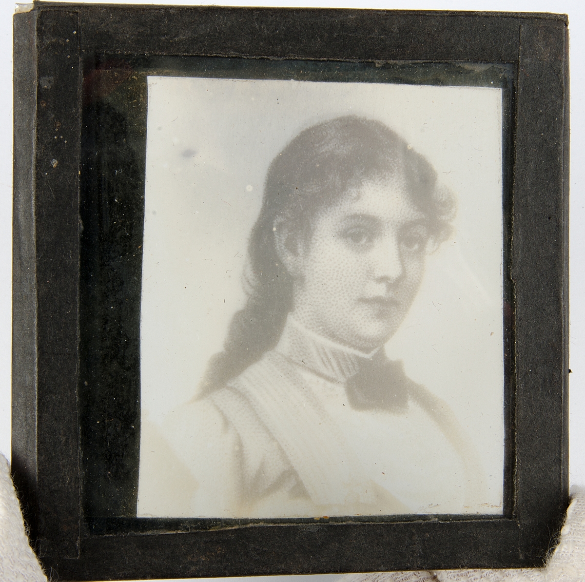 Tjugoåtta skioptikonbilder med motiv från bl.a. olika historiska händelser och sagor. Merparten i färg. Vissa skioptikonbilder, såsom avbildade personer, i sv/v. De flesta har en rosa, gul eller svart tejp som håller ihop de två glasplåtar i vilka motivet är fastsatt i. Vissa av bilderna är numrerade eller märkta med en bokstav.