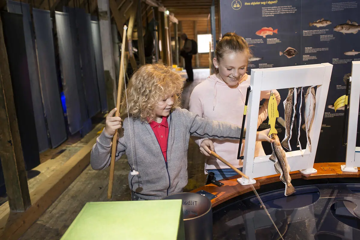 To barn fisker i fiskedammen på Norges Fiskerimuseum, i utstillingen ressurser til låns.