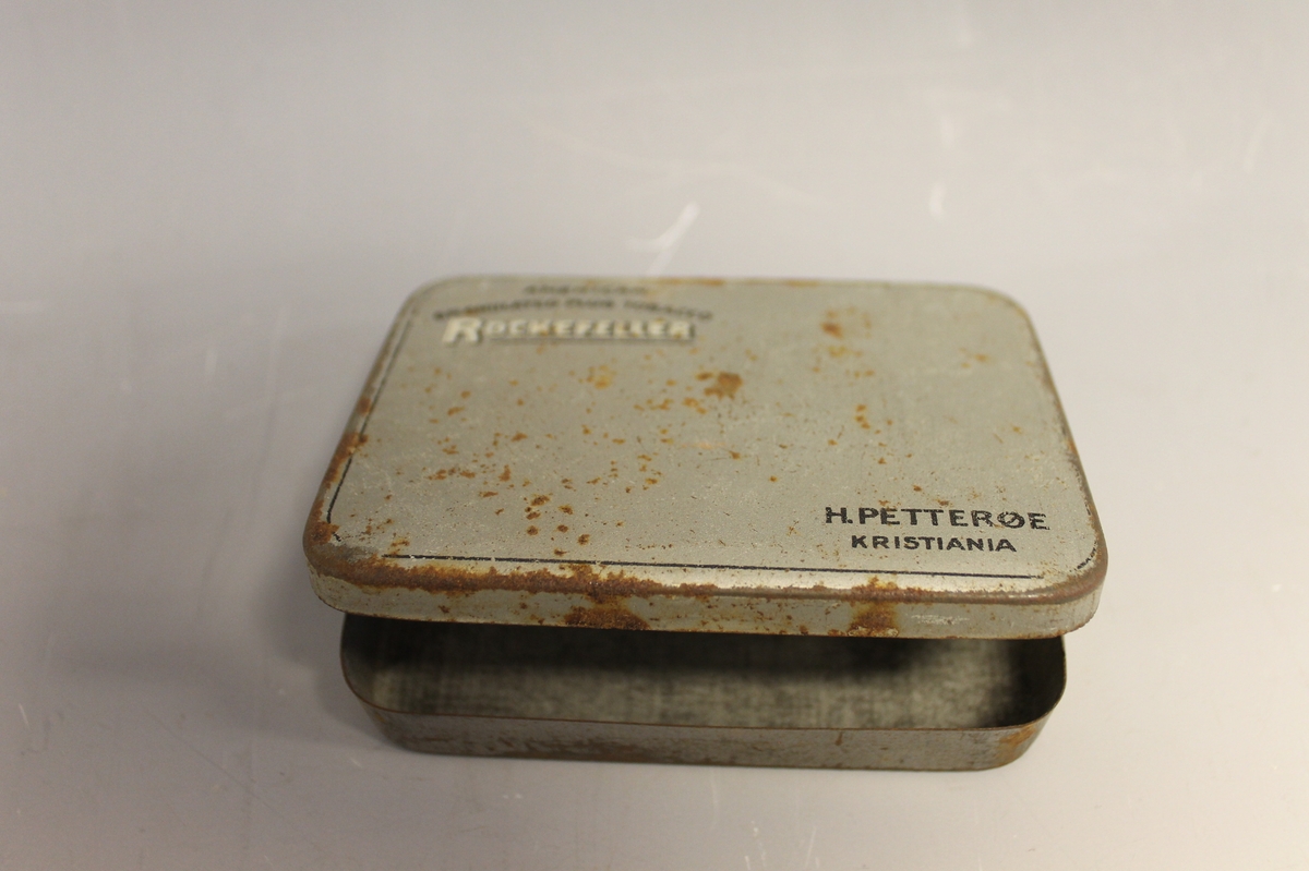 På lokket: AMERICAN GRANULATED PLUD TOBACCO ROCKEFELLER H: PETTERØE KRISTIANIA, inni lokket: H. PETTERØES ROCKEFELLER Bull Dog REGISTRERET, tegning av bulldog