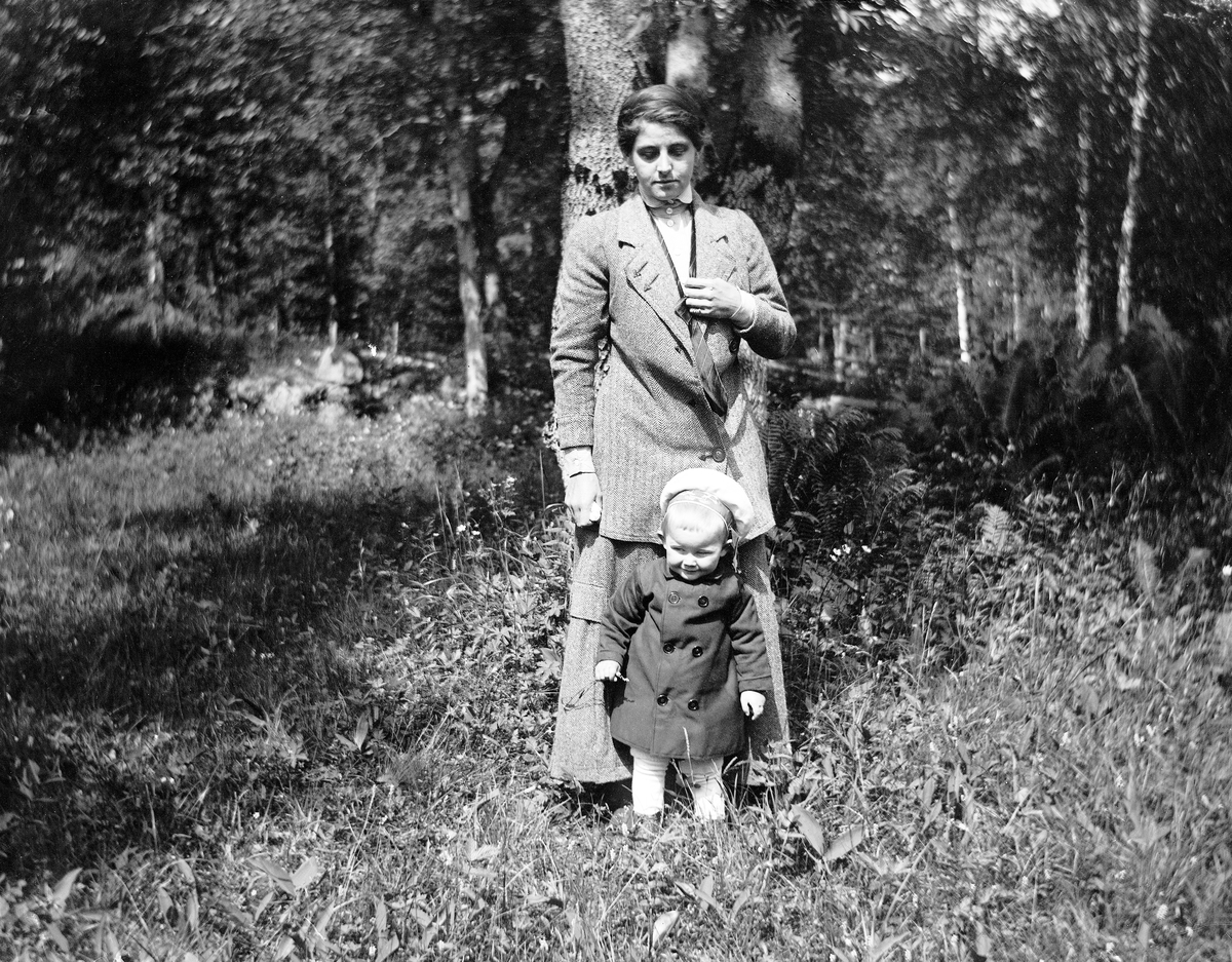 Kvinne og barn ute i skogen.