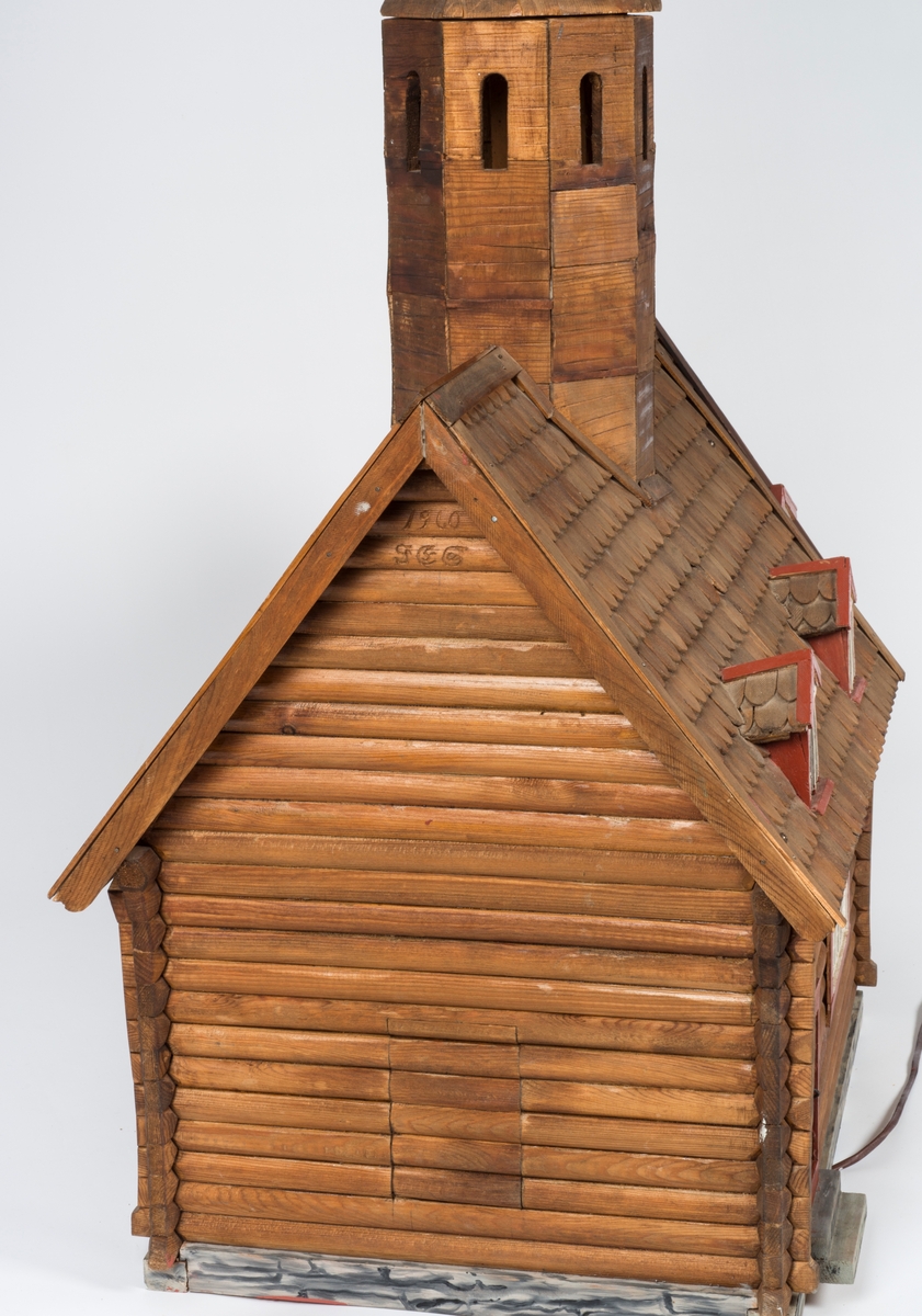 Modell av Trefoldighetskirken før påbygging av sakristi og våpenhus og påsetting av panel.

A: kirken.
B: tårnet.