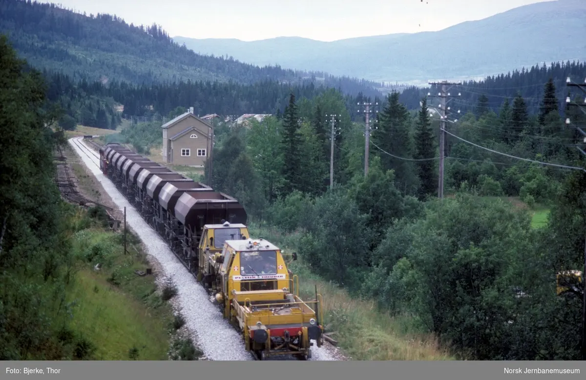 Sørgående arbeidstog med diesellok Di 3 611, ballastvogner og pakkemaskin bakerst passerer Grønfjelldal stasjon