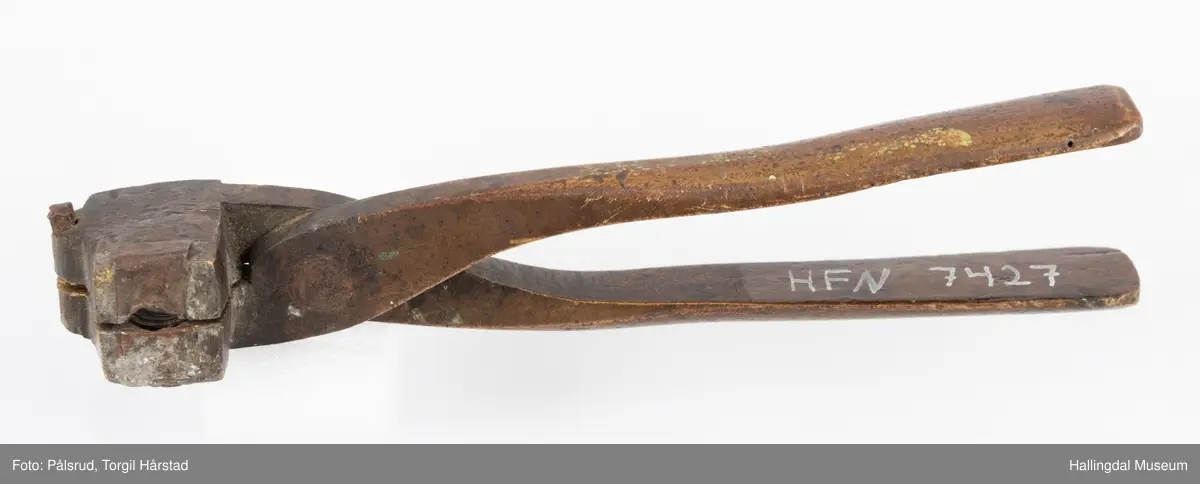Kuleform, eller kuletang til støping av blykuler. Antatt av messing. Formen er avlang og rektangulær med en halvrund form på enden der en liten tapp kan føres inn i et hull når formen lukkes. Armene bøyer svakt bak og er festet i krysset med en nagle. Formen er godt brukt og har et hull i bunnen. Det er også noe som antas å være rester etter bly. 
