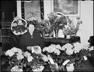 Kvinna omgiven av blommor, Östhammar, Uppland 1952