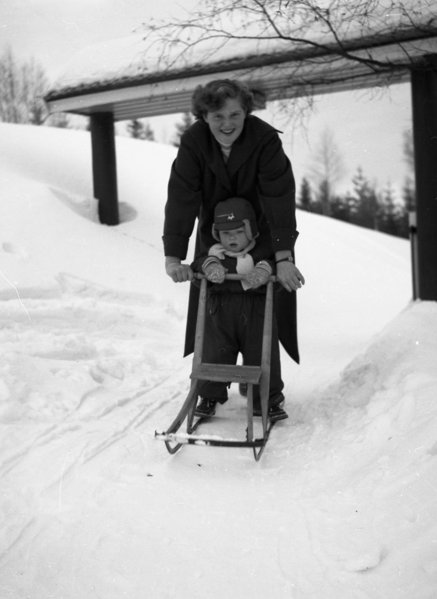 En kvinne og et barn i helfigur på spark.